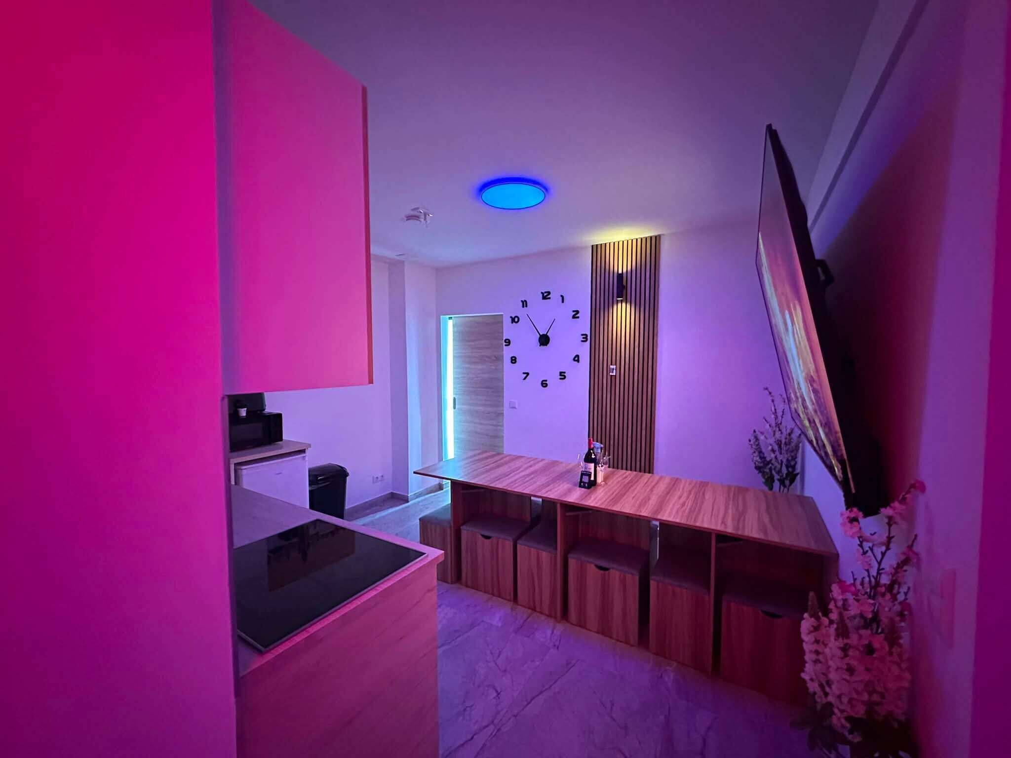 A modern kitchen with a wooden countertop, a built-in oven, and a wall-mounted clock.