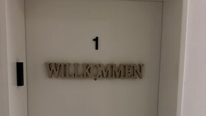 A door with a number '1' and the word 'WILLKOMMEN' indicating a welcome sign. - Ferienwohnung im Bramfelder 1 (Wandsbek-Hamburg)