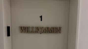 Eine Tür mit der Nummer 1 und dem Schriftzug 'WILLKOMMEN', ein Willkommensschild.