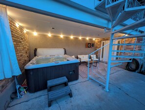 A hot tub with a wooden bench, a white sofa, and a staircase. - Bountiful Haven, sleeps 10, Hot Tub, near SLC, 3 bedrooms (Bountiful)