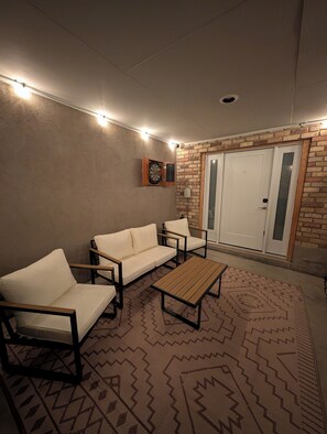 A room with a white sofa, two armchairs, a wooden coffee table, a dartboard, and a patterned rug. - Bountiful Haven, sleeps 10, Hot Tub, near SLC, 3 bedrooms (Bountiful)