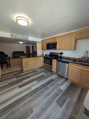 A kitchen with wooden cabinets, a stainless steel stove, and a microwave. - Bountiful Haven, sleeps 10, Hot Tub, near SLC, 3 bedrooms (Bountiful)