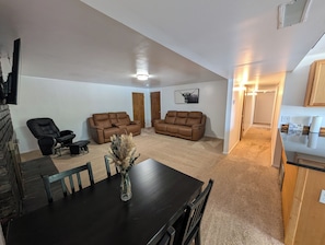 A living room with two brown sofas, a black dining table, and a black chair. - Bountiful Haven, sleeps 10, Hot Tub, near SLC, 3 bedrooms (Bountiful)