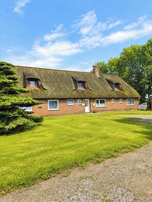 A traditional brick house with a thatched roof, a front door, and a small porch. - "Reethus – A Little Getaway" Vacation Rental in a Quiet Setting, Near the North Sea and the Islands (Bosbüll)