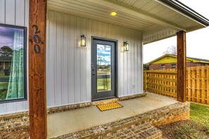 A residential entryway with a gray door, two wall-mounted lanterns, and a number '200' on the left. - Modern 2-bedroom house with AC in delightful Muscle Shoals (Muscle Shoals)