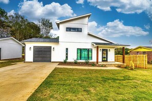 A modern two-story house with a garage, a covered porch, and a well-maintained lawn. - Modern 2-bedroom house with AC in delightful Muscle Shoals (Muscle Shoals)