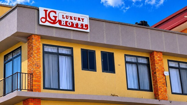 A building with a sign that reads 'JG Luxury Hotel' on the facade.