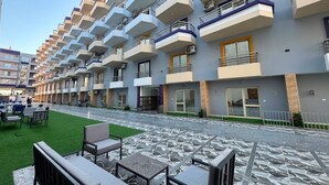 A hotel with multiple balconies, outdoor seating, and a paved walkway. - Lavonda Beach resort hurghada (Hurghada)