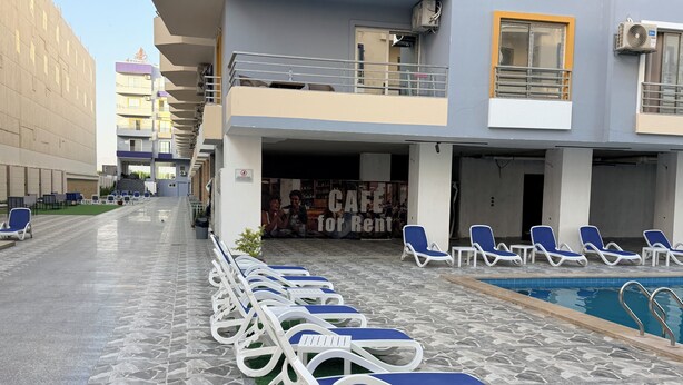 A poolside area with lounge chairs and a sign for 'CAFE for Rent'. - Lavonda Beach resort hurghada (Hurghada)