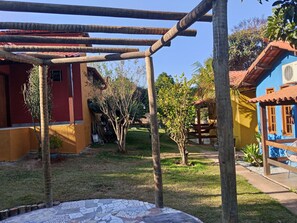 A courtyard with a pergola, a small tree, and a tiled patio area. - Little house Azul near Inhotim Brumadinho. (Brumadinho)