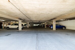 An underground parking garage with multiple levels, concrete pillars, and cars parked. - Hummingbird Hideaway - Executive Resort-style Condo (Phoenix)