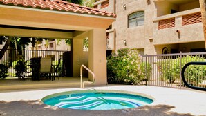 A swimming pool with a wavy edge, surrounded by a covered patio area with outdoor furniture. - Hummingbird Hideaway - Executive Resort-style Condo (Phoenix)