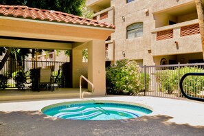 A swimming pool with a wavy edge, surrounded by a covered patio area with outdoor furniture. - Hummingbird Hideaway - Executive Resort-style Condo (Phoenix)