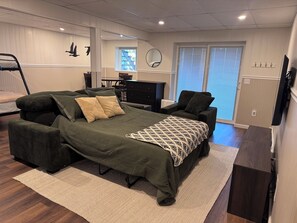 Une chambre à coucher avec un grand lit, un bureau, une chaise et une fenêtre avec des stores.