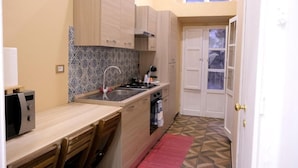 A compact kitchen with a microwave, stove, sink, and cabinets.