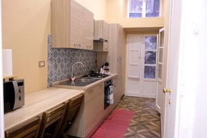 Cocina compacta con microondas, estufa, lavaplatos y armarios.