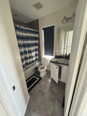 A bathroom with a toilet, a shower curtain, a window, and a sink. - 3 Bedroom+ 2.5 Bath Townhouse Close to a Ravine - Enjoy a peaceful neighbourhood (Ajax)