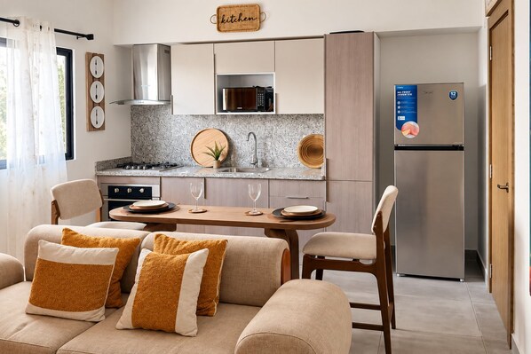 Una cocina moderna con comedor, un refrigerador y un letrero en la pared.