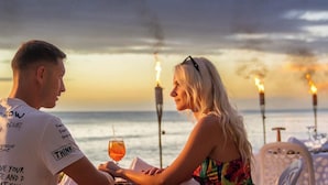A couple dining at a table with a view of the ocean and a sunset. - ANYA 6 Downtown Bayahíbe Retreat Pool  (Bayahíbe)