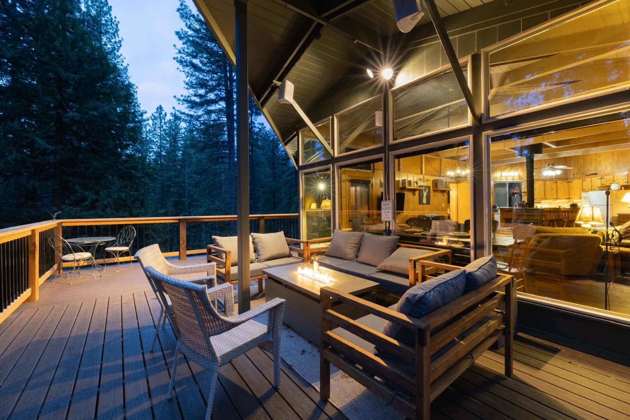 Une terrasse extérieure avec des meubles en bois et un foyer.