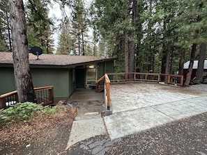 A building with a staircase leading to a covered entrance, surrounded by tall trees. - Delightful cabin Sleeps 14! 5 Min To Pinecrest Lake! Family Gatherings Welcome! (Long Barn)
