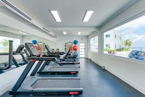 A gym with treadmills, weight machines, and exercise balls. - Chic Poolside Condo with Ocean Views (West Bay)