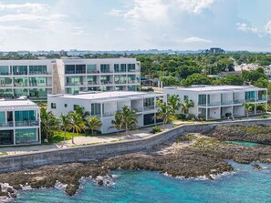 Un hotel a la costa d'arquitectura moderna, amb diverses edificacions amb balcons i grans finestrals.