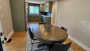 A dining area with a round table, chairs, and a patterned rug.