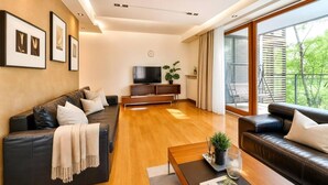 Ein modernes Wohnzimmer mit einer Couch, einem Couchtisch und einem Fernseher.