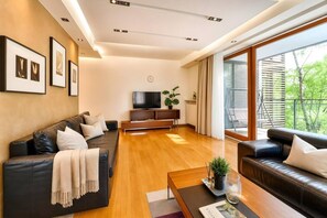 Ein modernes Wohnzimmer mit einer Couch, einem Couchtisch und einem Fernseher.