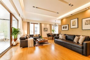 Een moderne woonkamer met een bank, salontafel en een eethoek.
