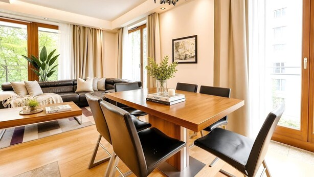 Ein modernes Wohnzimmer mit Essbereich, ausgestattet mit einer Sofagarnitur, einem Couchtisch und einem Esstisch mit Stühlen.