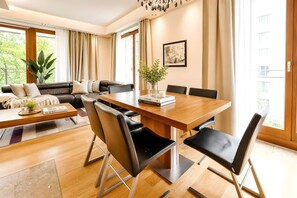 Ein modernes Wohnzimmer mit Essbereich, ausgestattet mit einer Sofagarnitur, einem Couchtisch und einem Esstisch mit Stühlen.