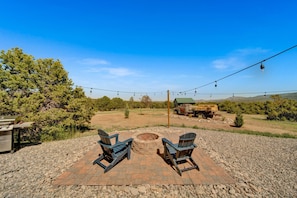 An outdoor seating area with two Adirondack chairs, a fire pit, and a grill. - The King Ranch I South Fork, Colorado Retreat (South Fork)