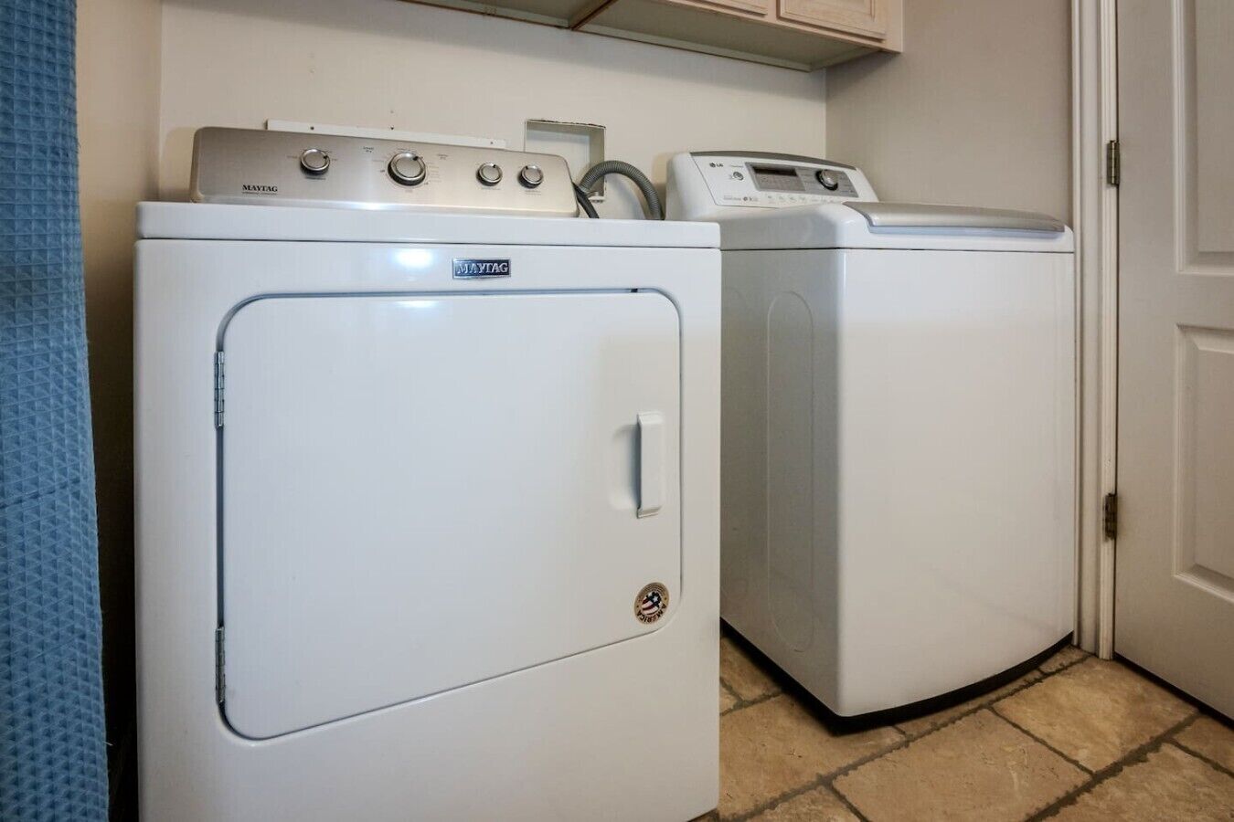 A laundry room with two white Maytag washers and dryers.