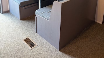 A small room with a kitchenette, a television, a sofa, and a table.
