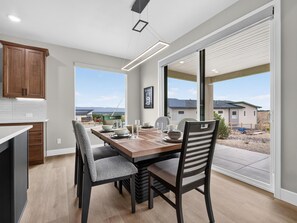A modern kitchen with a dining area, large windows, and a view of the surrounding landscape. - NEW! Mesa View Modern: Luxury Living (Grand Junction)