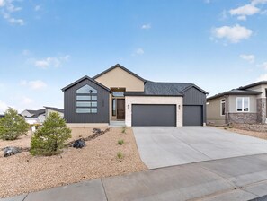 A modern two-story house with a garage, a driveway, and a landscaped front yard. - NEW! Mesa View Modern: Luxury Living (Grand Junction)