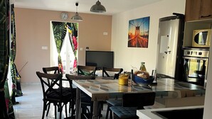 A modern kitchen with a dining area, featuring a large island, stainless steel appliances, and pendant lighting. - Small vacation rental near the beaches (Triaize)