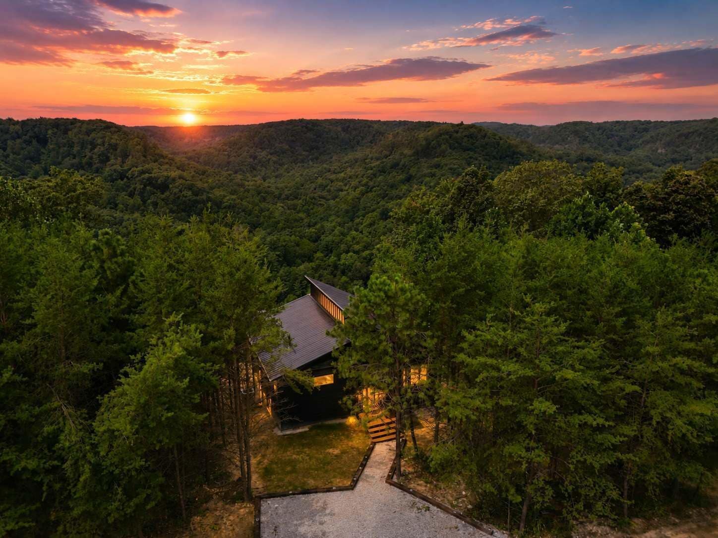 A secluded cabin surrounded by dense forest, with a clear path leading to the entrance.