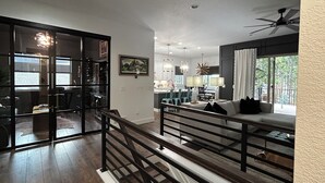 A spacious living area with a staircase, a dining area, and a kitchen. - USAFA Retreat, 4BR/ 4BA, Front Range Views, Nestled in the Pines (Monument)