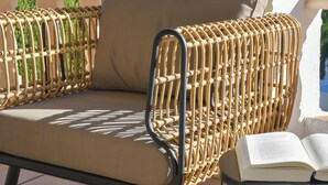 A wicker lounge chair with a cushion, positioned on a balcony with a view of greenery. - Casa Amandine, within walking distance of La Fustera Beach (Benissa)