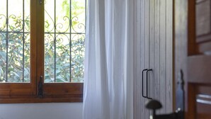 A wooden door with a metal handle, a window with a metal grill, and a white curtain partially drawn. - Casa Amandine, within walking distance of La Fustera Beach (Benissa)