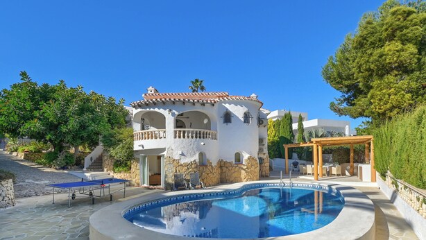 A pool area with a circular pool, a pergola, and a building with a tiled roof and arches. - Casa Amandine, within walking distance of La Fustera Beach (Benissa)