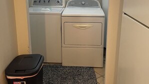 Una sala amb rentadora, assecadora i paperera.