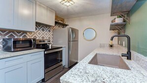 A modern kitchen with a built-in microwave, oven, and stainless steel refrigerator. - Magnolia House; Grille/Firepit/Patio View! (Tampa)