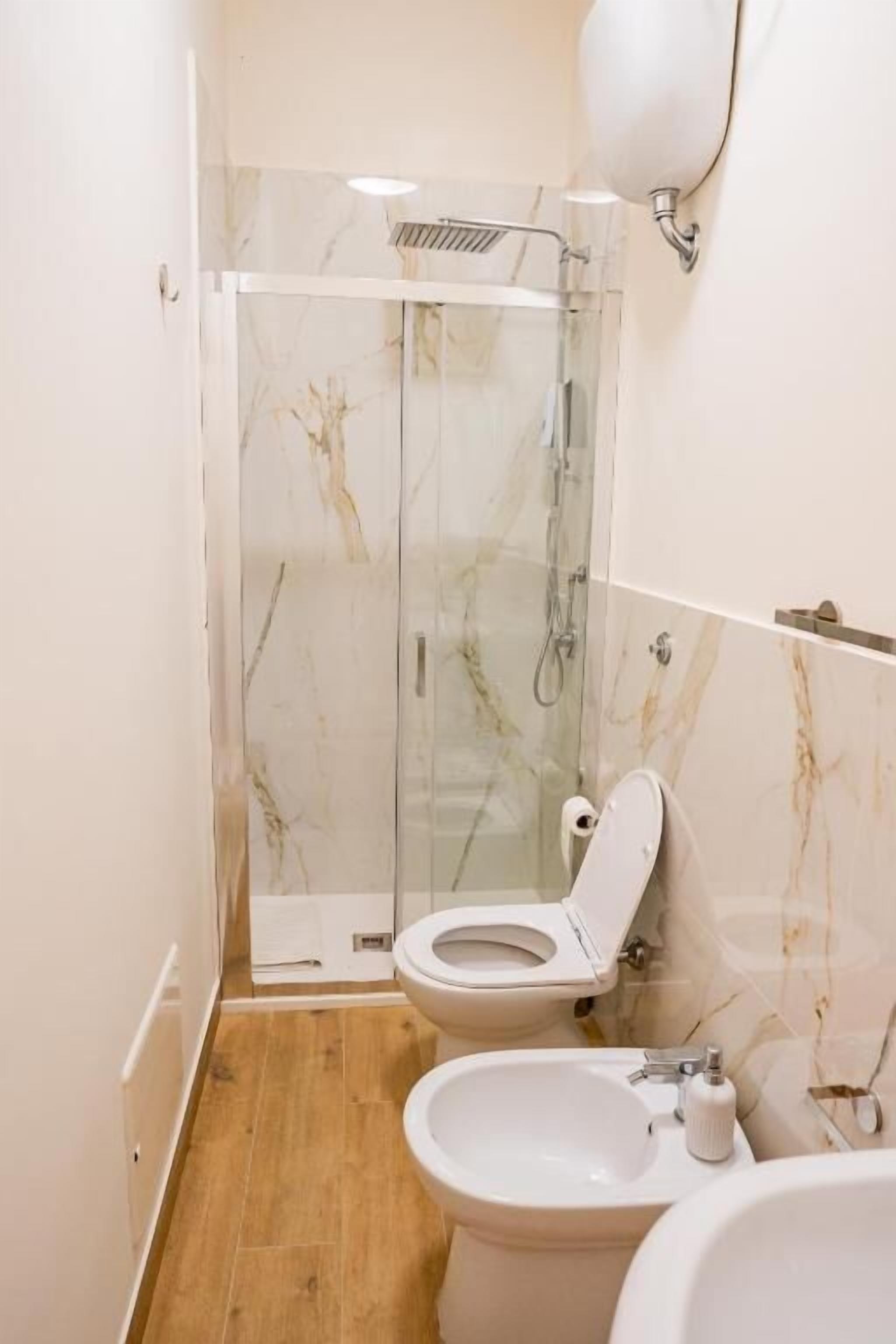 Une salle de bain avec une douche à parois de verre, des toilettes et un bidet.