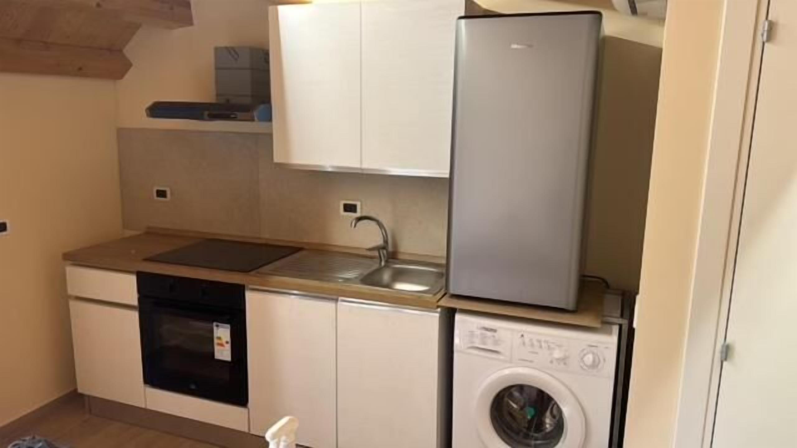 Une cuisine compacte équipée d’un lave-vaisselle, d’une machine à laver et d’un réfrigérateur.