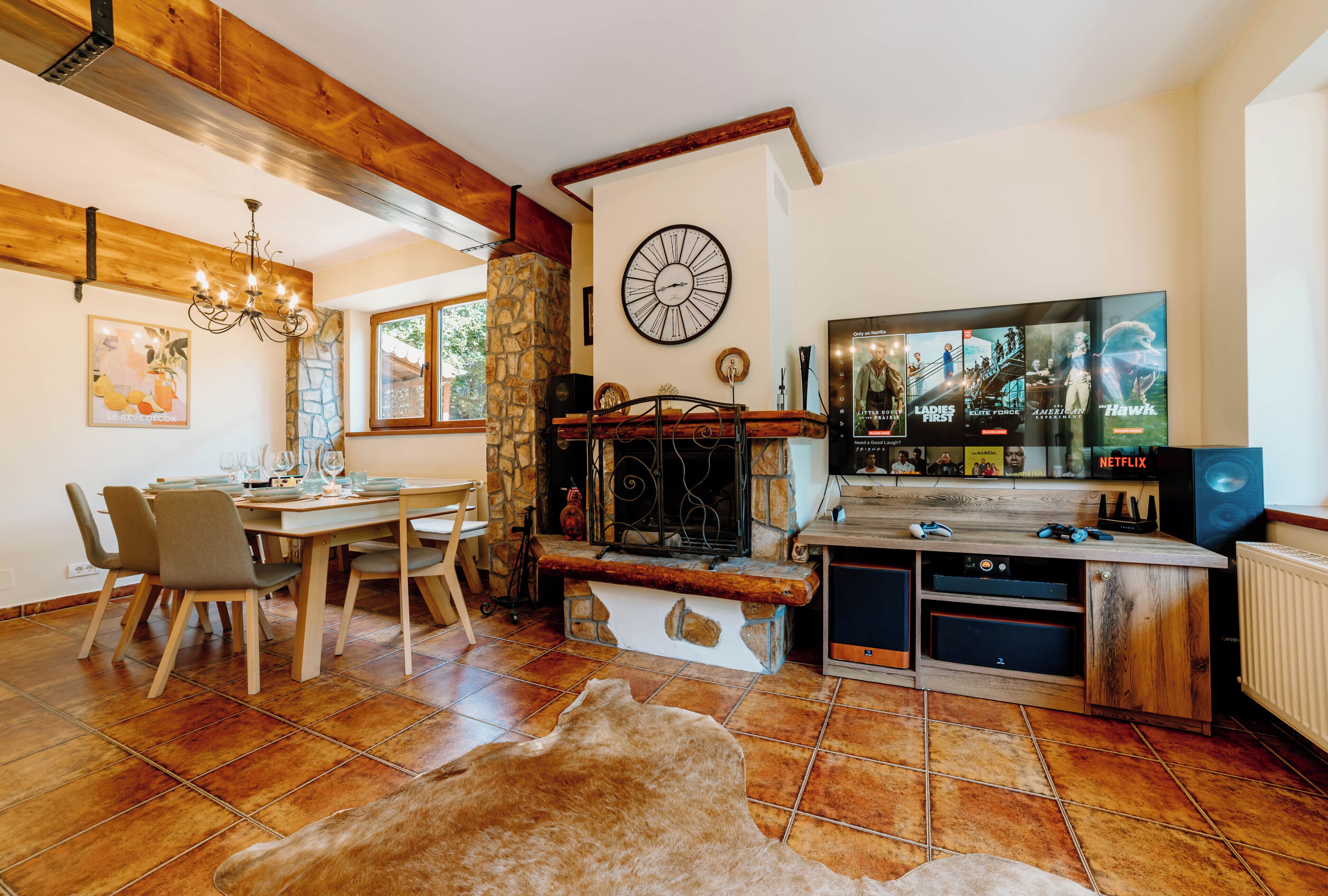 A cozy living room with a fireplace, a dining area, and a television displaying Netflix content.
