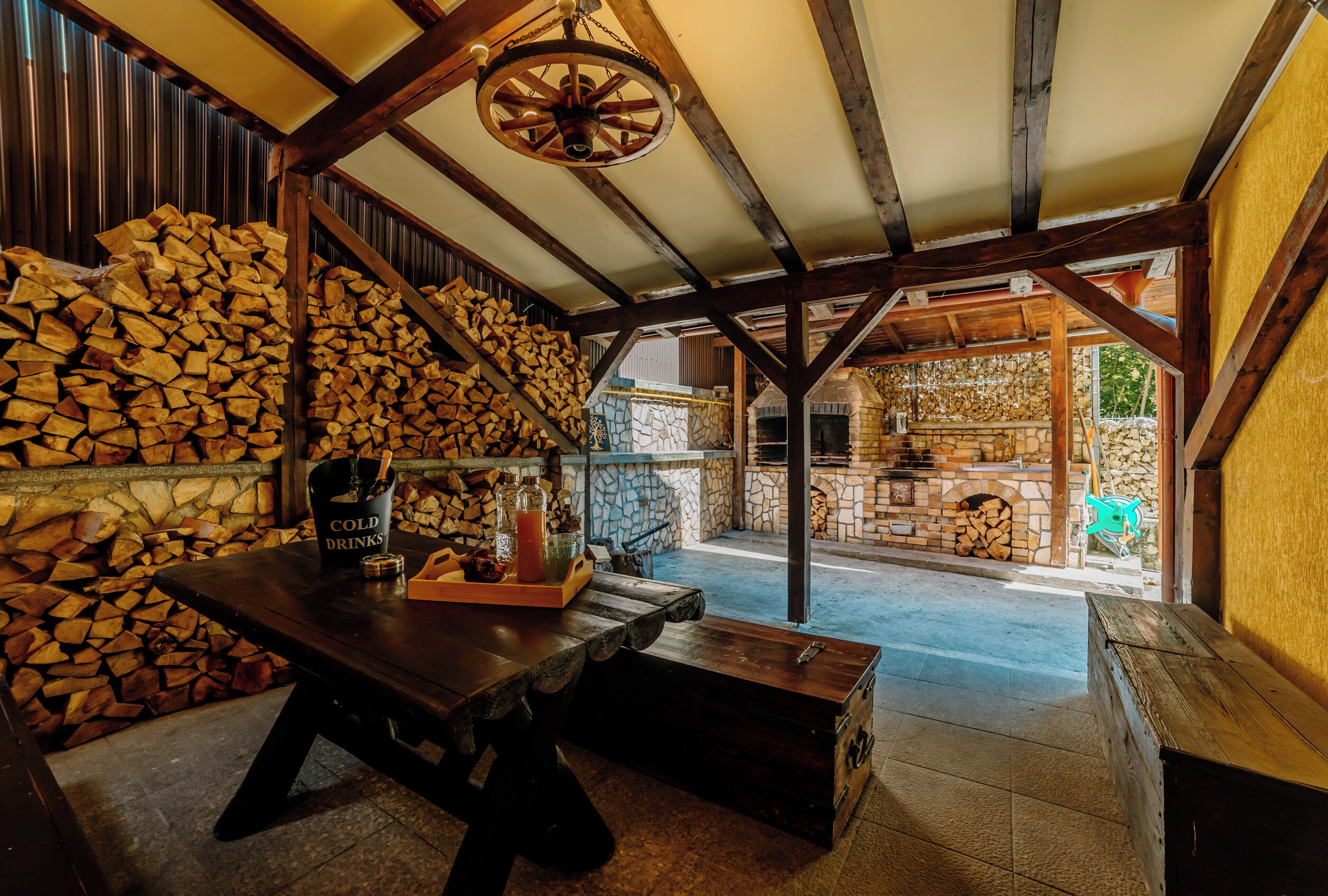 A rustic interior with a wooden table, a basket of bread, and a bottle of cold drinks.